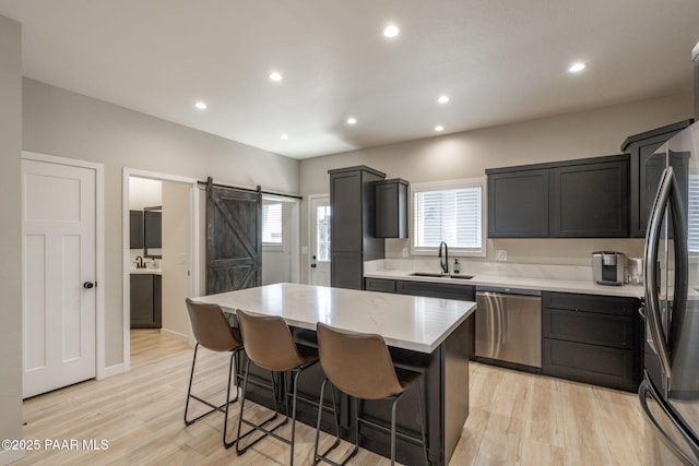 2905 S Omega Dr, Dewey-Humboldt, AZ 86329 - kitchen with stainless steel appliances, light countertops, a barn door, a sink, and a breakfast bar area