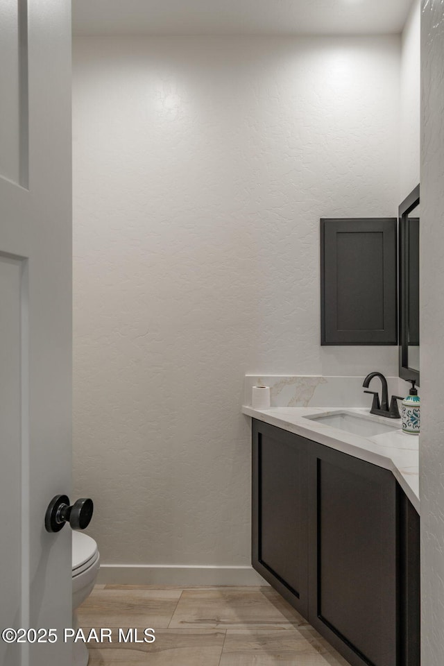 2905 S Omega Dr, Dewey-Humboldt, AZ 86329 - bathroom featuring toilet, vanity, baseboards, and wood finished floors