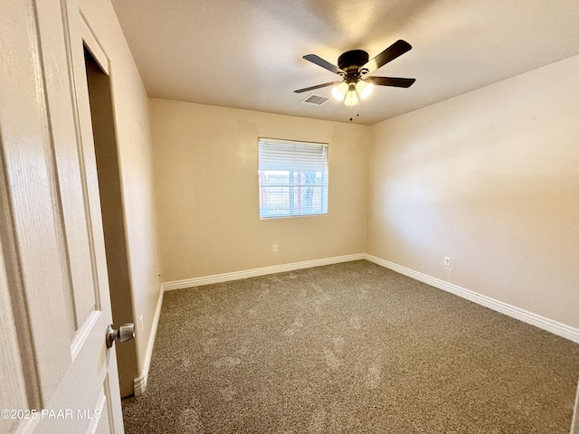 carpeted spare room with visible vents, baseboards, and ceiling fan