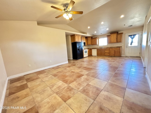 kitchen with white appliances, baseboards, visible vents, lofted ceiling, and brown cabinets