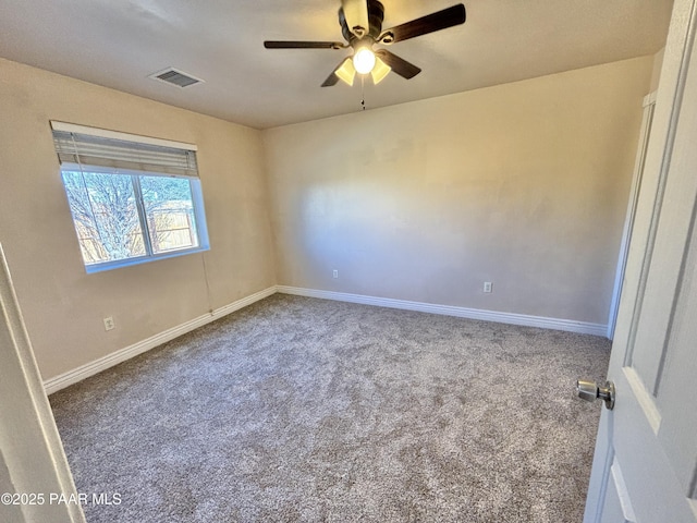 carpeted spare room featuring visible vents, baseboards, and ceiling fan