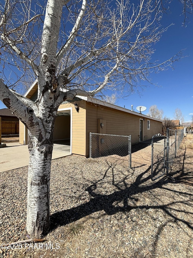 exterior space with a gate, fence, a garage, and driveway