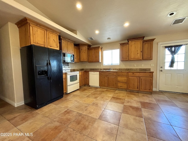 kitchen featuring a sink, visible vents, white appliances, and lofted ceiling