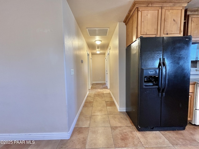 hallway featuring light tile patterned floors, baseboards, and visible vents