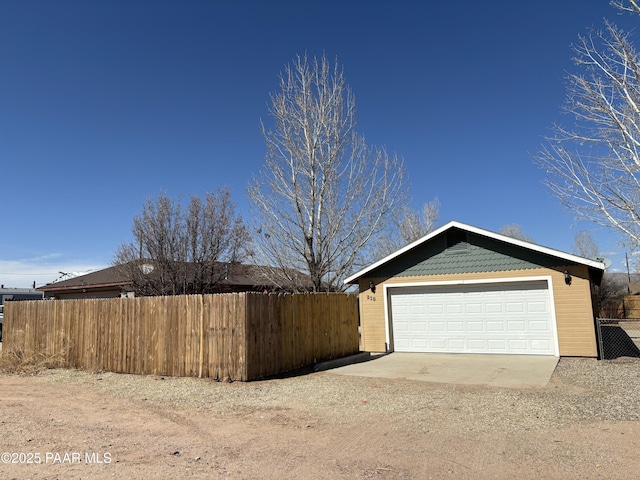 detached garage featuring fence