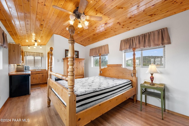 bedroom with lofted ceiling, light wood-style floors, wooden ceiling, and a sink