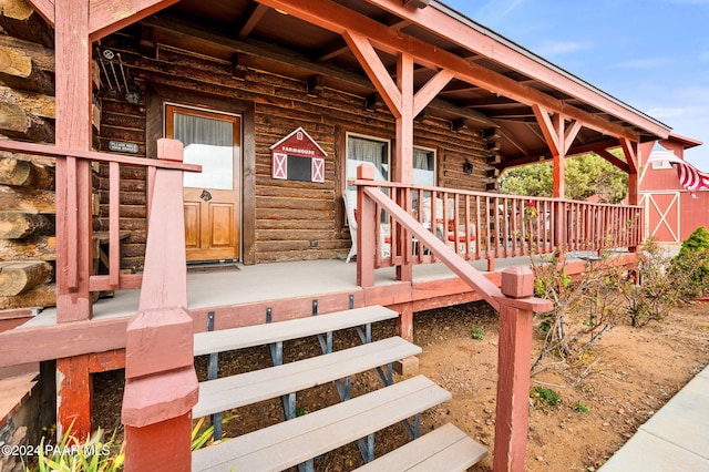 view of exterior entry featuring log siding