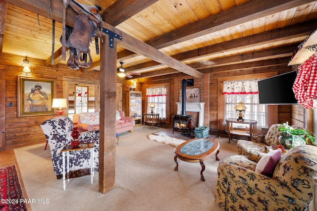 carpeted living area with wooden ceiling, a wood stove, plenty of natural light, and wood walls
