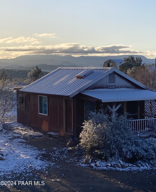 view of side of property with a mountain view and metal roof