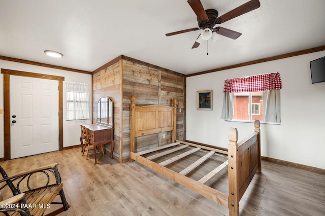 entryway with baseboards, ceiling fan, ornamental molding, and light wood finished floors