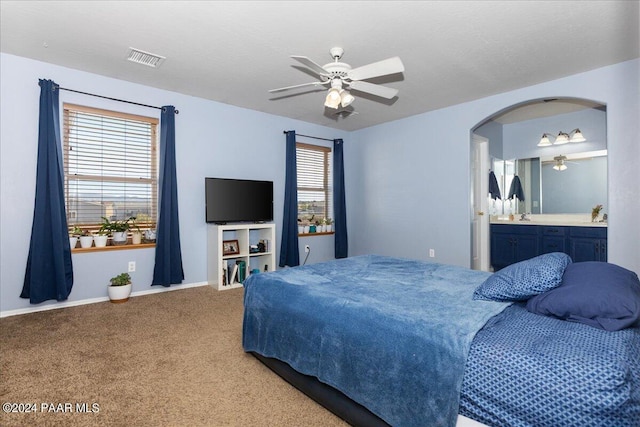 bedroom with carpet, ceiling fan, and ensuite bathroom