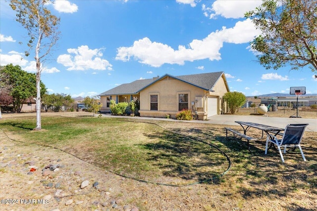 rear view of property featuring a lawn and a garage