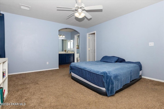 bedroom with carpet, ensuite bathroom, and ceiling fan