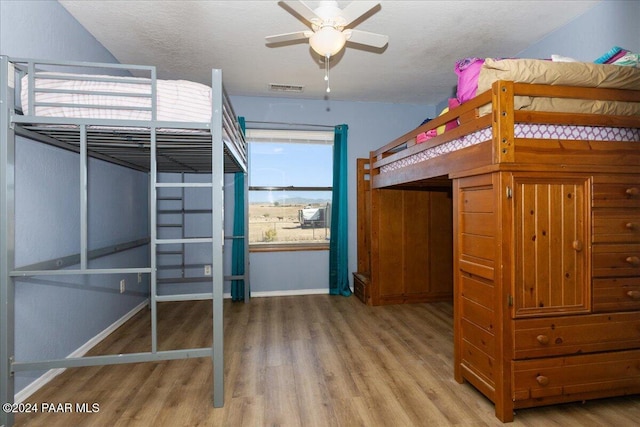 unfurnished bedroom with ceiling fan, wood-type flooring, and a textured ceiling