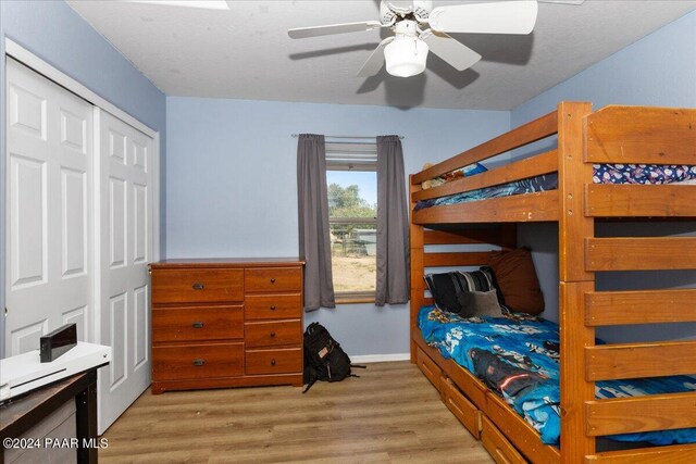 bedroom with ceiling fan, light wood-type flooring, and a closet