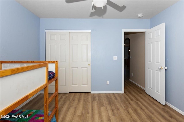 bedroom featuring hardwood / wood-style flooring, ceiling fan, and a closet