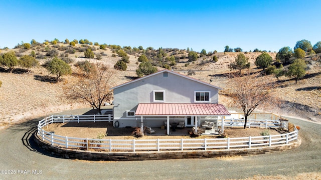 back of property featuring a rural view and a patio area