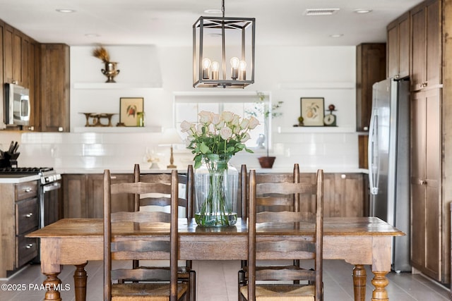 dining area with a notable chandelier and tile patterned floors