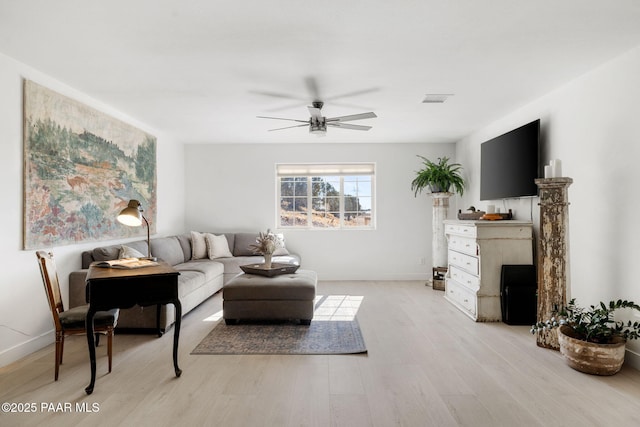 living room featuring a fireplace, light hardwood / wood-style flooring, and ceiling fan