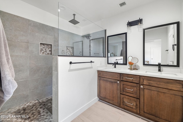 bathroom with vanity and tiled shower