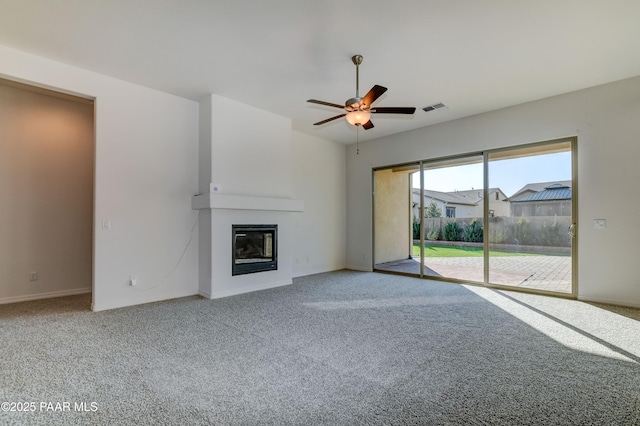 unfurnished living room featuring ceiling fan, a large fireplace, and carpet floors