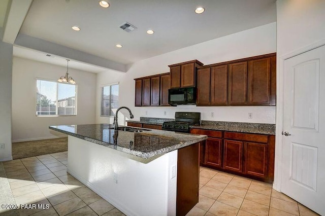 kitchen featuring sink, black appliances, light tile patterned floors, a chandelier, and an island with sink