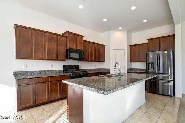 kitchen featuring black appliances, light tile patterned flooring, sink, and a kitchen island with sink