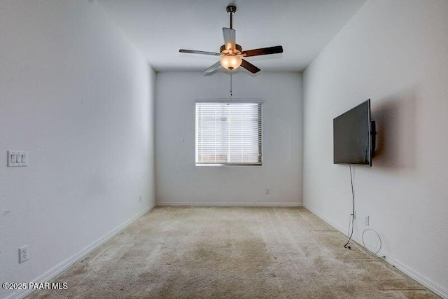 empty room featuring ceiling fan and light carpet