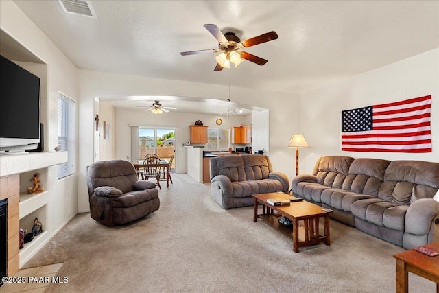 12912 E Santiago St, Dewey-Humboldt, AZ 86327 - living area featuring a ceiling fan, light carpet, and a tiled fireplace