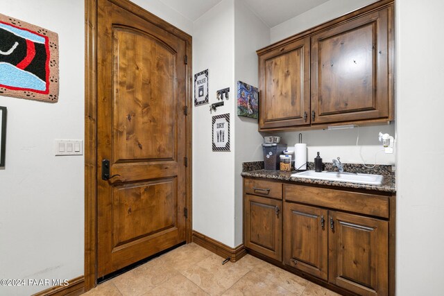 kitchen featuring dark stone countertops and sink