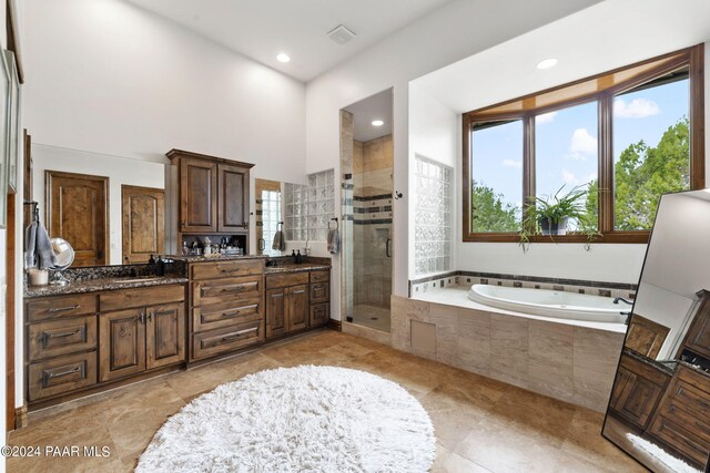 bathroom featuring separate shower and tub and vanity