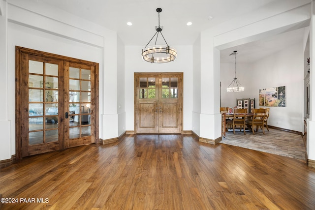 foyer with a chandelier, french doors, and wood-type flooring