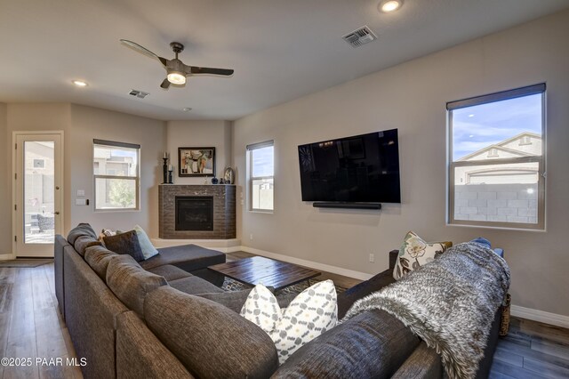 living room featuring ceiling fan with notable chandelier and dark hardwood / wood-style floors