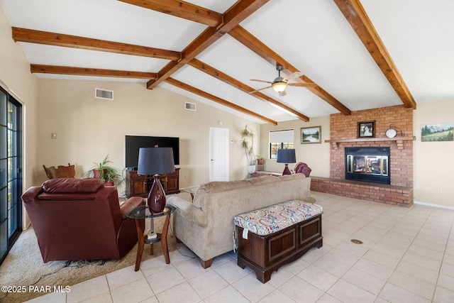 living room with vaulted ceiling with beams, light tile patterned floors, a brick fireplace, and visible vents