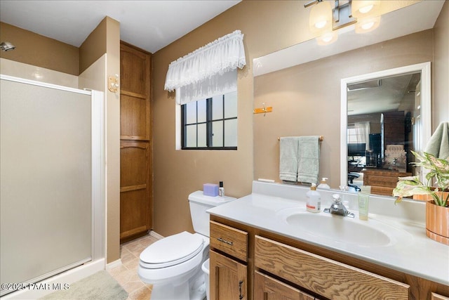 full bath featuring toilet, a shower stall, vanity, and tile patterned floors