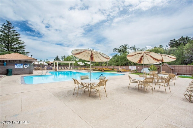 community pool with a patio area and fence
