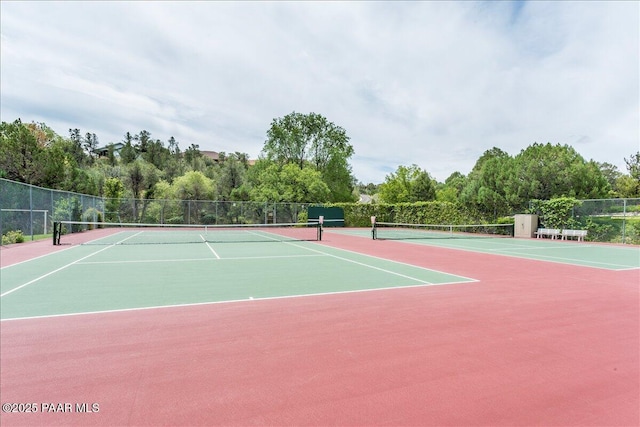 view of tennis court featuring community basketball court and fence