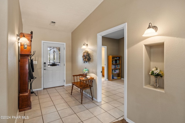 foyer with light tile patterned floors and vaulted ceiling