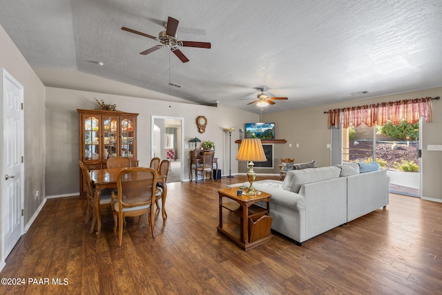 living room with dark hardwood / wood-style floors, ceiling fan, a textured ceiling, and vaulted ceiling