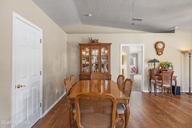 dining space featuring a textured ceiling, dark hardwood / wood-style flooring, and lofted ceiling