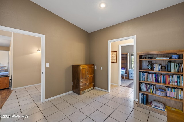 interior space featuring light tile patterned floors and lofted ceiling