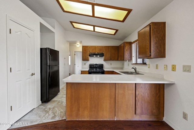 kitchen with light countertops, vaulted ceiling, a peninsula, black appliances, and a sink