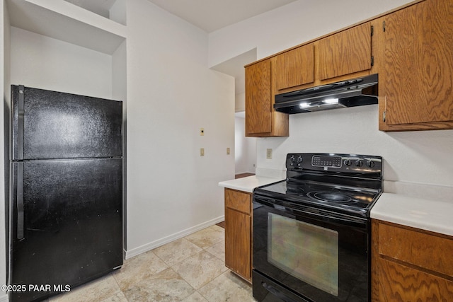 kitchen with under cabinet range hood, brown cabinets, black appliances, and light countertops