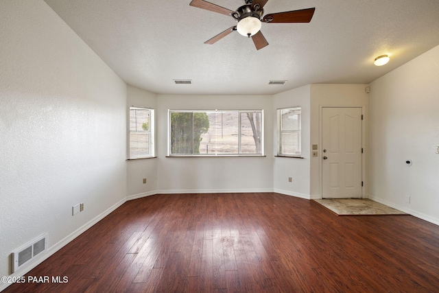 unfurnished room with visible vents, a textured ceiling, ceiling fan, and hardwood / wood-style floors