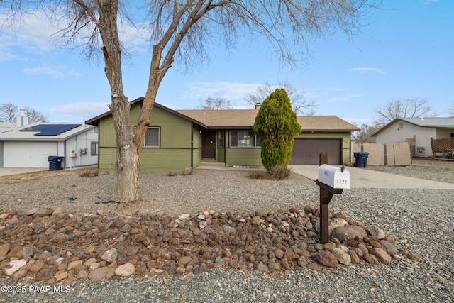 ranch-style home featuring driveway, an attached garage, and fence