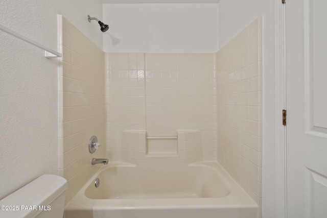 full bathroom featuring toilet, shower / bathtub combination, and a textured wall