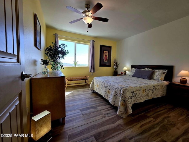 bedroom with baseboards, multiple windows, ceiling fan, and wood finished floors