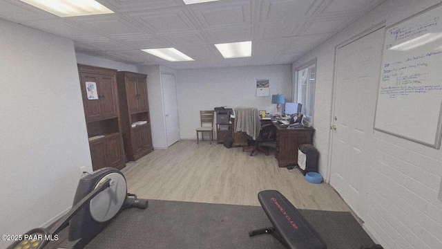 unfurnished bedroom with wood walls, a drop ceiling, and concrete flooring