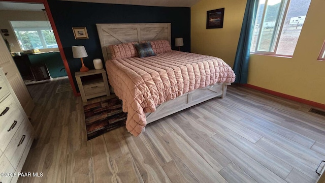bedroom with ceiling fan, baseboards, light wood-style floors, and a textured ceiling