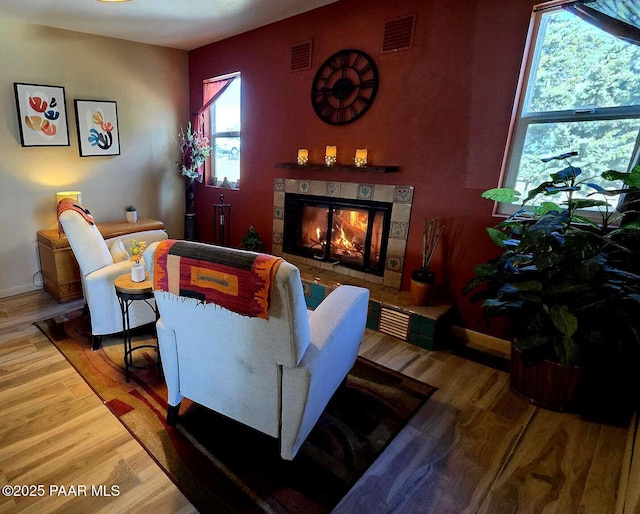 sitting room featuring a tiled fireplace and visible vents